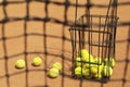 Tennis net against clay court basket with balls Royalty Free Stock Photo