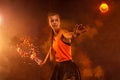 Tennis player with fire ball. Beautiful girl teenager and athlete with racket in orange sporswear and hat on tennis court. Sport Royalty Free Stock Photo