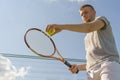 Tennis player man hand making a shot holding a ball and a racket against sky Royalty Free Stock Photo