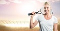 Tennis player smiling against stadium with bright lights and evening sky Royalty Free Stock Photo