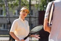 Tennis player young girl holding racquet and listen advices from her professional coach. Sports woman in activewear hold Royalty Free Stock Photo