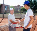 Tennis players of different generations shake hands before tennis match Royalty Free Stock Photo