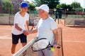 Tennis players of different generations shake hands before tennis match Royalty Free Stock Photo