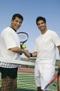 Tennis Players shaking hands over net on court portrait Royalty Free Stock Photo