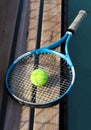 Tennis racket and ball on a bench at the blue hard tennis court. Hard lighting. Summer sport concept. Active lifestyle and healthy Royalty Free Stock Photo