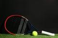 Tennis racket and ball on green grass against black background. Space for text Royalty Free Stock Photo