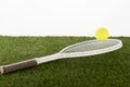 Tennis racket and ball on green grass isolated on white Royalty Free Stock Photo
