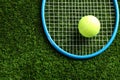 Tennis racket and ball on green grass, top view. Space for text Royalty Free Stock Photo