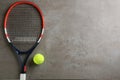 Tennis racket and ball on grey table, flat lay. Space for text Royalty Free Stock Photo