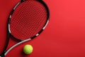 Tennis racket and ball on red background, flat lay. Space for text Royalty Free Stock Photo