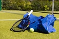 Tennis racket, ball and sports bag on sunny outdoor grass tennis court Royalty Free Stock Photo