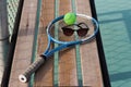 Tennis racket, tennis ball and sunglasses on a bench at the blue hard tennis court. Hard lighting. Summer sport concept. Active Royalty Free Stock Photo