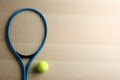 Tennis racket and ball on wooden table, flat lay. Space for text Royalty Free Stock Photo
