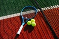 Tennis racket and three standart balls with net shadow cast on it