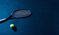 Tennis racket and yellow ball located on dark blue tennis court