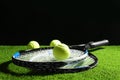 Tennis rackets and balls on green grass against dark background. Space for text Royalty Free Stock Photo