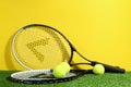 Tennis rackets and balls on green grass against yellow background. Sports equipment Royalty Free Stock Photo