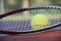 Tennis racquet and yellow tennis ball on outdoor court Royalty Free Stock Photo