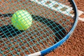 Tennis raquet with tennis ball on ash court Royalty Free Stock Photo