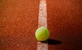 Tennis Sport background concept with copy space. Close-up tennis ball on the line point on clay court. Royalty Free Stock Photo