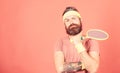 Tennis sport and entertainment. Concentrated on tennis court. Athlete hipster hold tennis racket in hand red background Royalty Free Stock Photo