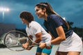 Tennis sport people concept. Mixed doubles player hitting tennis ball with partner standing near net Royalty Free Stock Photo