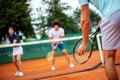 Tennis sport people concept. Mixed doubles player hitting tennis ball with partner standing near net Royalty Free Stock Photo