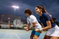 Tennis sport people concept. Mixed doubles player hitting tennis ball with partner standing near net Royalty Free Stock Photo