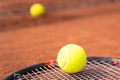 Tennis yellow ball on racket lying on clay court Royalty Free Stock Photo