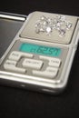 Diamonds on small digital scale in amount of tens of carats Royalty Free Stock Photo