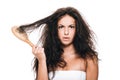 Brunette woman holding wavy unruly hair in comb isolated on white