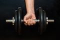 Tense male hand holding a dumbbell