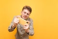 Tense nerd in shirt, glasses and mustache looks intently at the smartphone screen and plays mobile games. Funny serious gamer