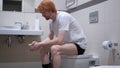 Tense Redhead Man Sitting in Toilet, Commode