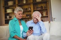 Tense senior couple looking at mobile phone