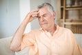 Tense senior man sitting on sofa in living room Royalty Free Stock Photo