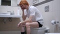 Tense Upset Redhead Man Sitting in Toilet, Commode