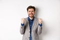 Tensed businessman feeling nervous and pressured, clenching fists and teeth, staring at camera, making money and looking