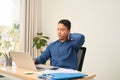 Tensed businessman sitting at table with laptop in office