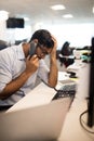 Tensed businessman talking on land line at desk