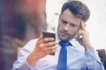 Tensed businessman using mobile phone