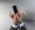 Tensed chain tied businessman hands hostage of mobile burnout