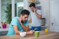 Tensed Man using phone at table