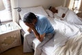 Tensed senior man sitting on bed