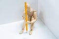 Tensed wooden figurine with a pencil sitting