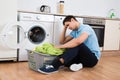 Tensed Man Looking At Laundry Basket By Washing Machine Royalty Free Stock Photo