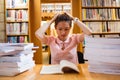Tensed young woman studying in library Royalty Free Stock Photo