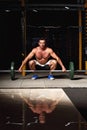 Tensing man lifting barbell in crossfit gym on dark sport club b Royalty Free Stock Photo