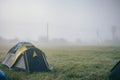 tent camp in the early foggy morning on a clearing near the forest