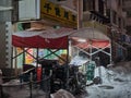 Tent cover over a bunch of storage items behind a store covered in snow in Shenyang, China